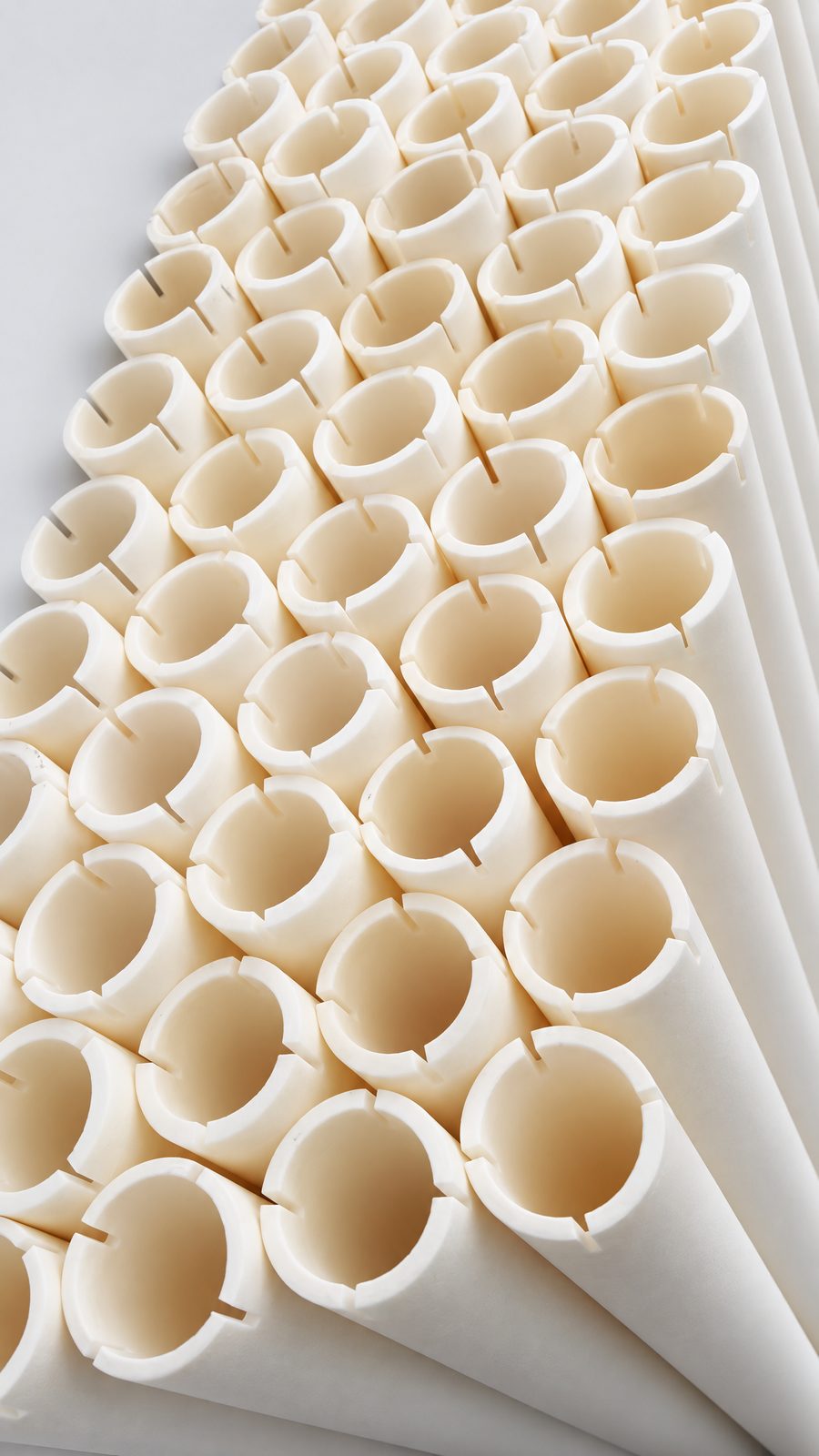 Large-diameter ceramic tubes stacked on their sides, showing the open ends and wall thickness.